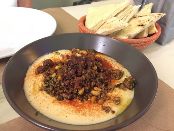 Hummus, merguez, piñones y pan de pita.