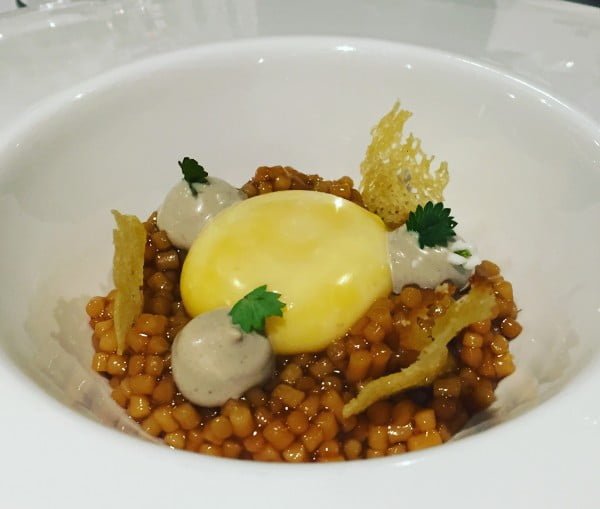 Huevo de caserío, guiso de trigo y jugo de pimientos a la brasa con pan de Mungia.